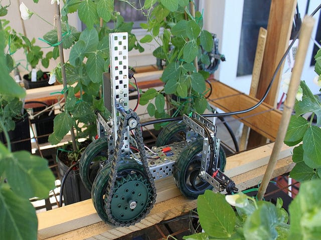 An agritechnology robot in a greenhouse with plants on it.