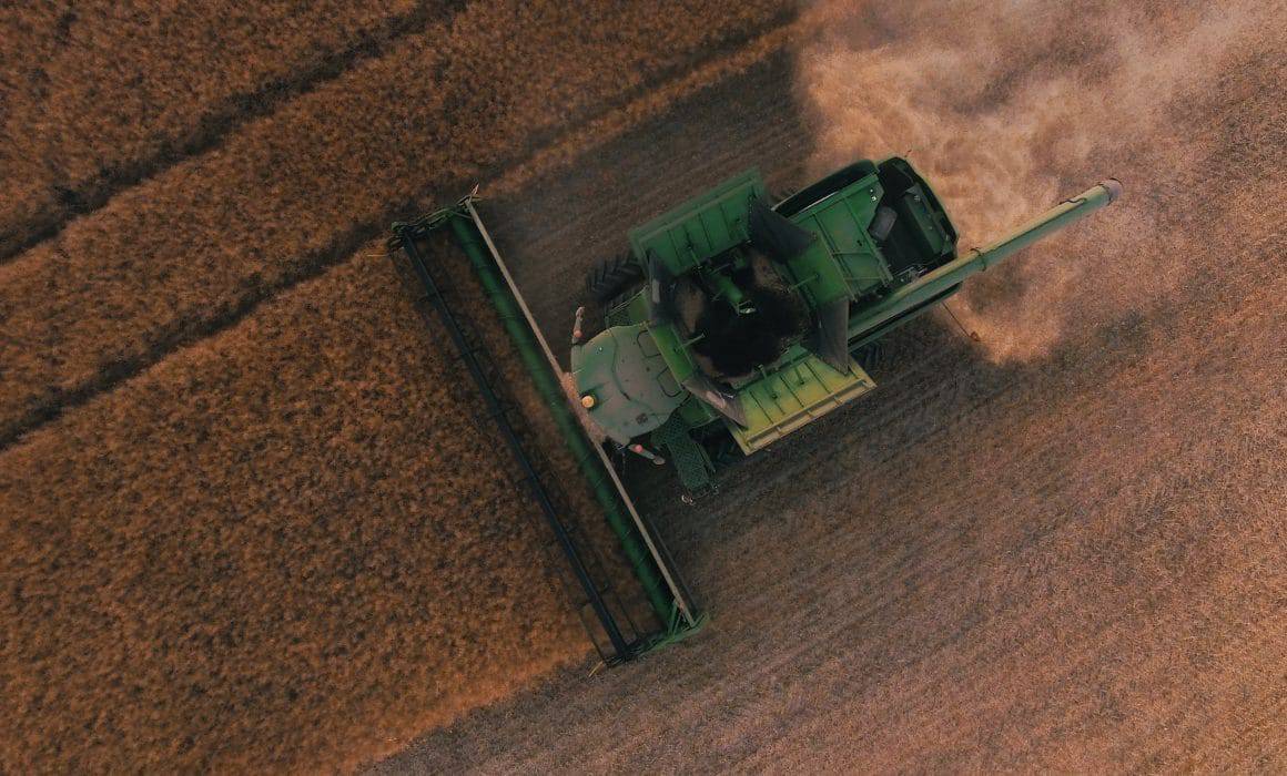 An aerial view of a combine harvester in a Louisiana field during the in-season harvest of crops.