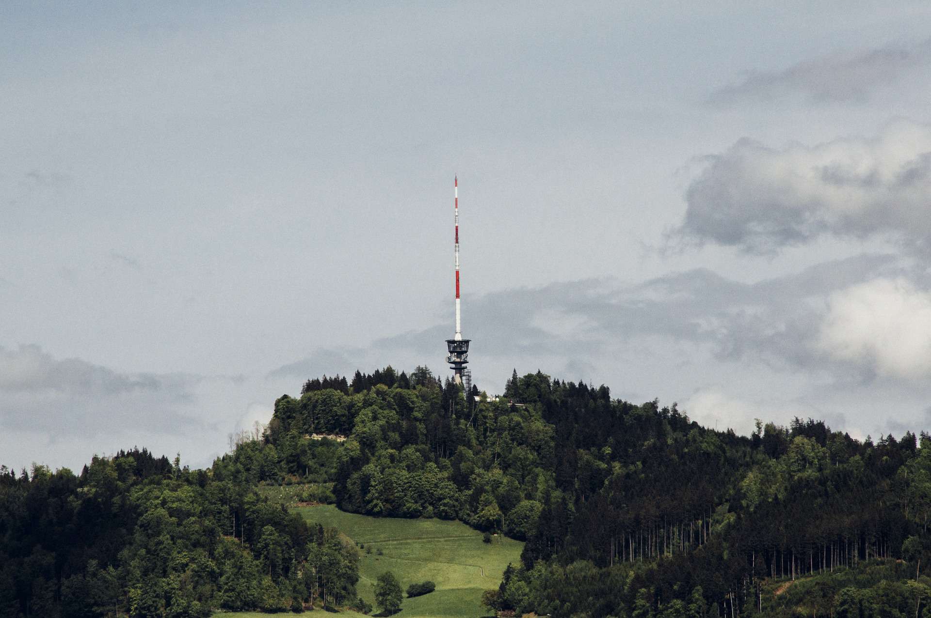 A tall tower, serving as an important element of rural infrastructure, stands proudly on top of a hill.