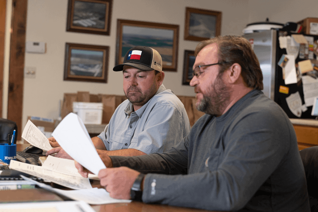 Farm operators reviewing paperwork.