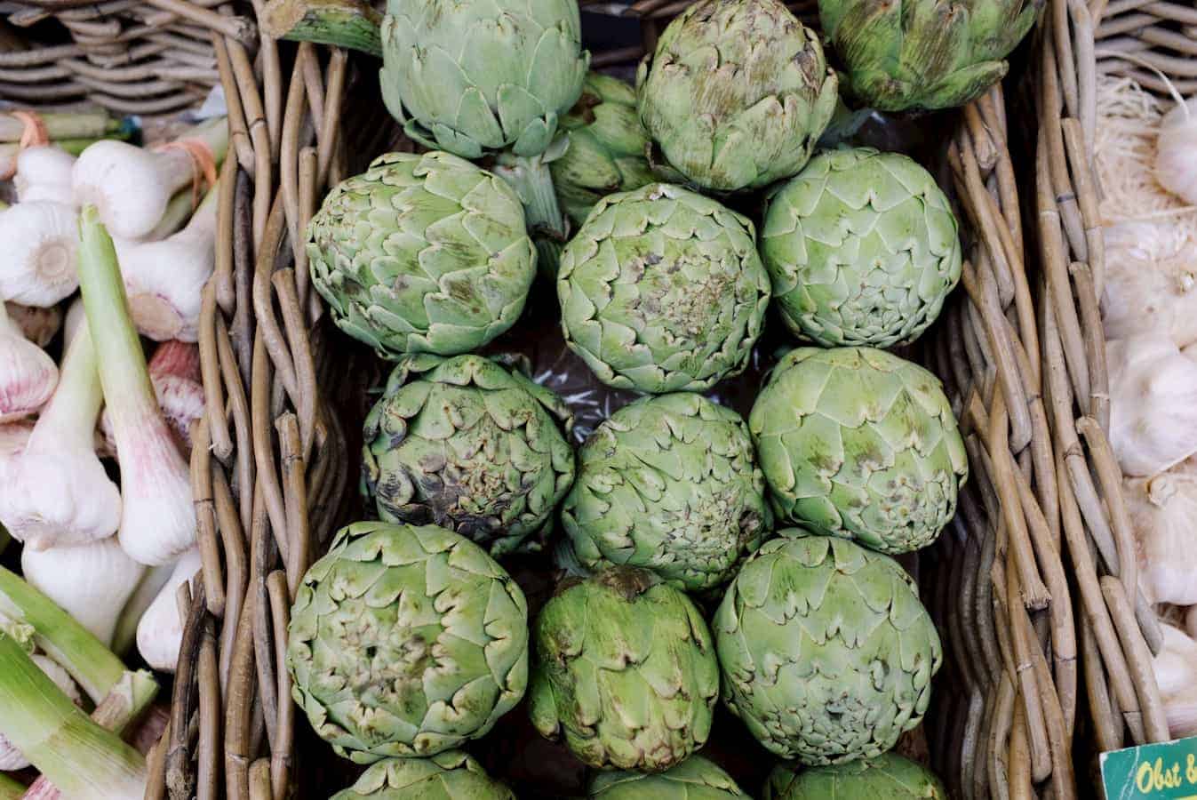 American farmer's artichokes and other vegetables are on display at a market.