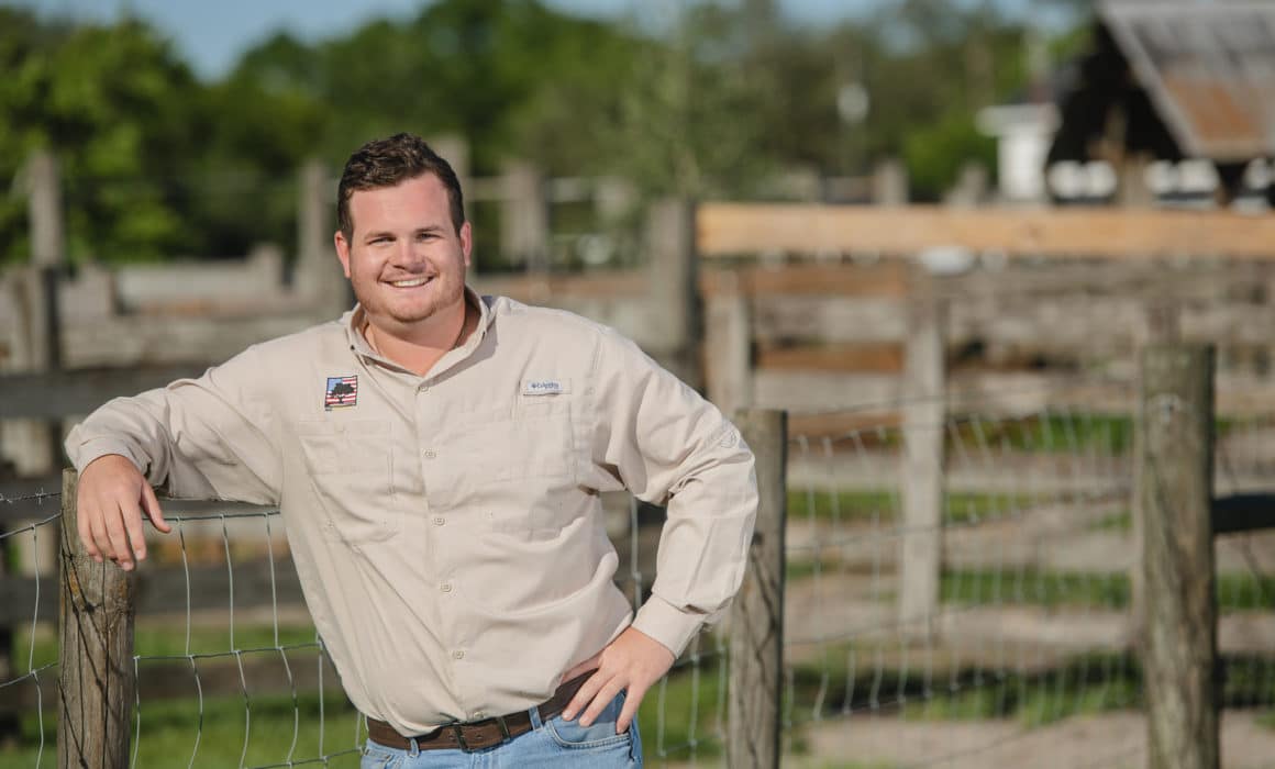 man leaning against a brown fence
