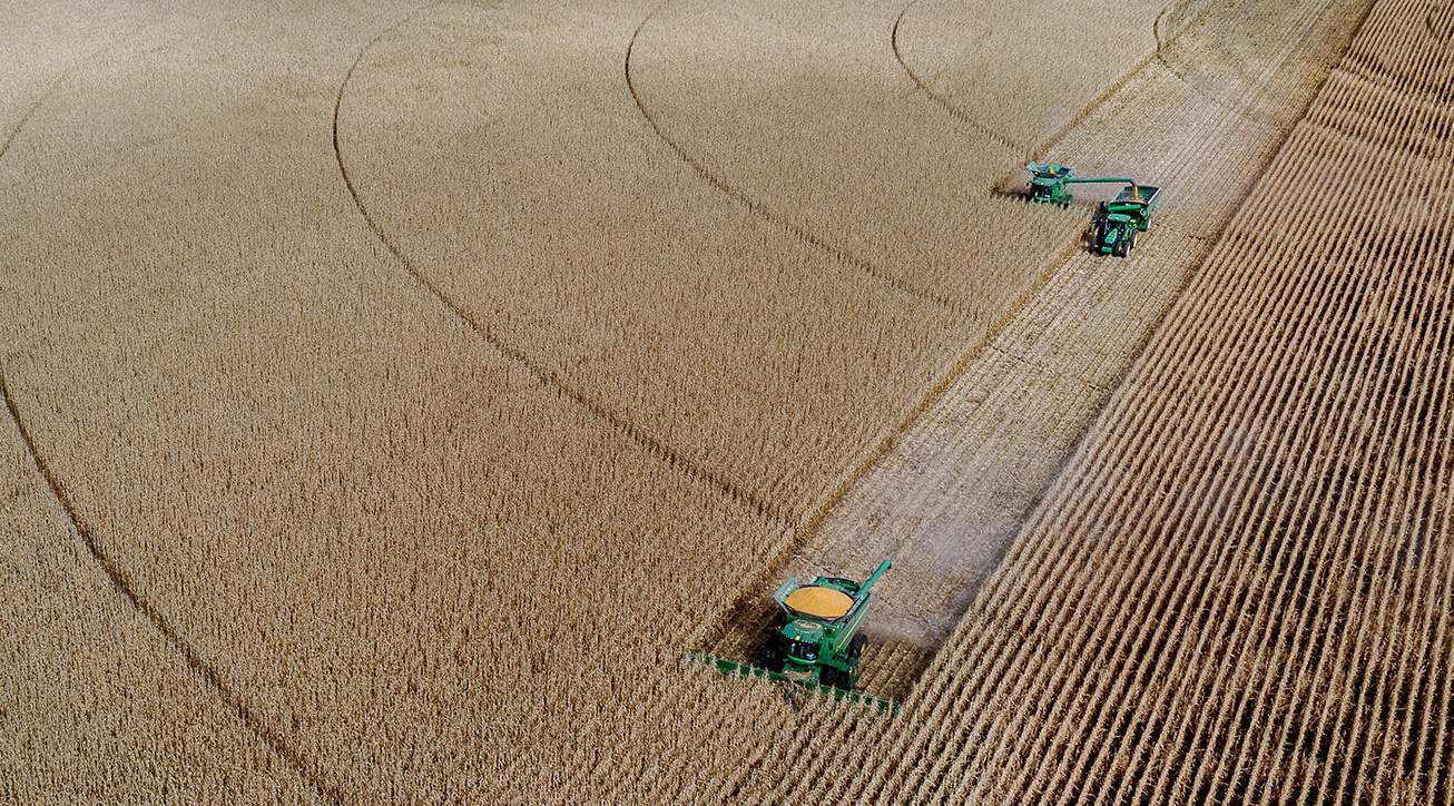 An aerial view of a combine harvester in a field.