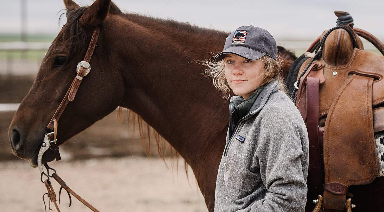 A cattle operator and her horse.
