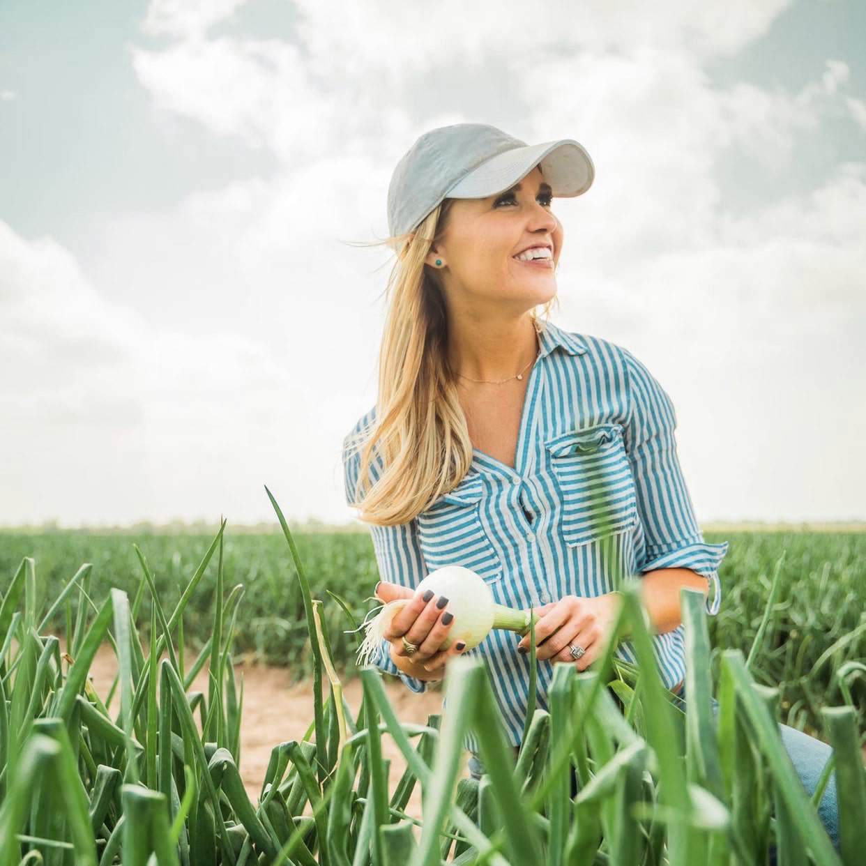 Agricultural content creator Michelle Martin standing in a field of green crops
