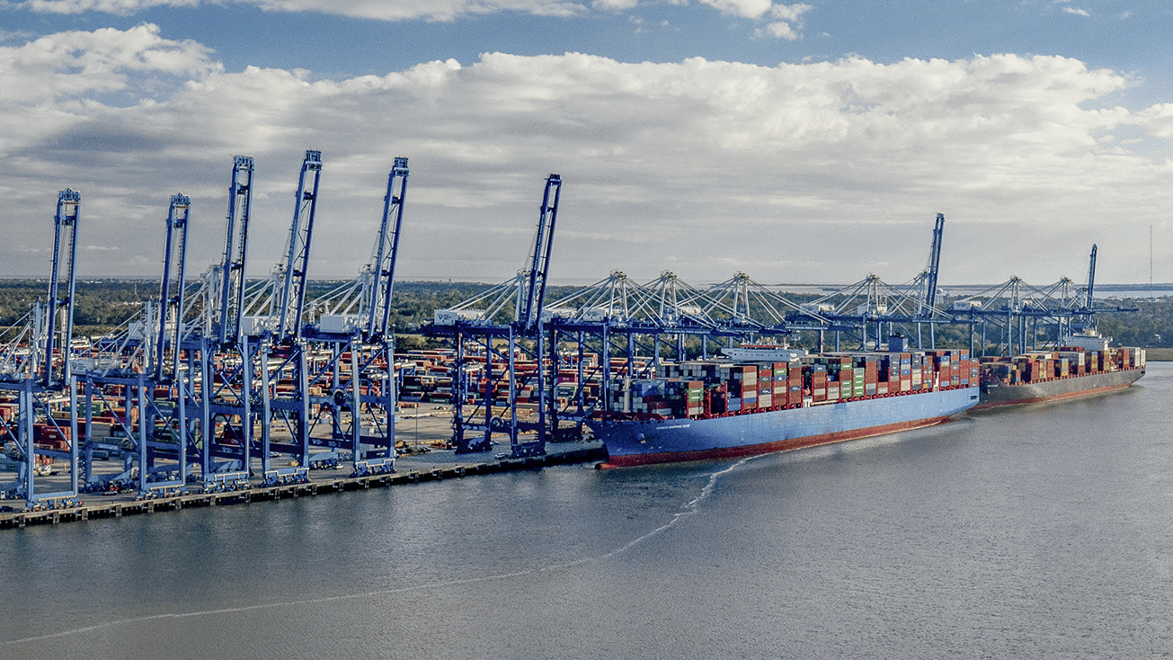 A blue container ship engaged in agricultural trade docked at a dock.