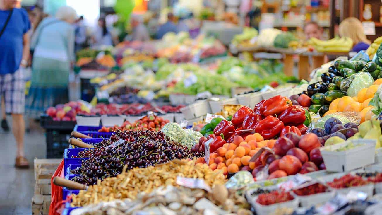 Various fruits and vegetables selling at a farmers market.