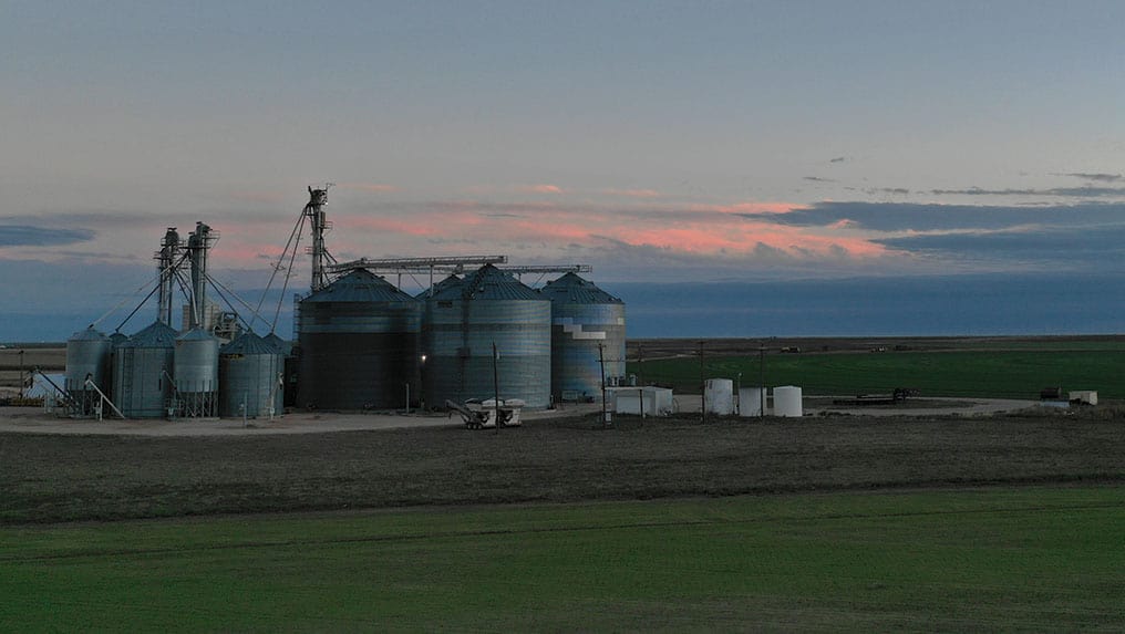 Silos in a field at sunset